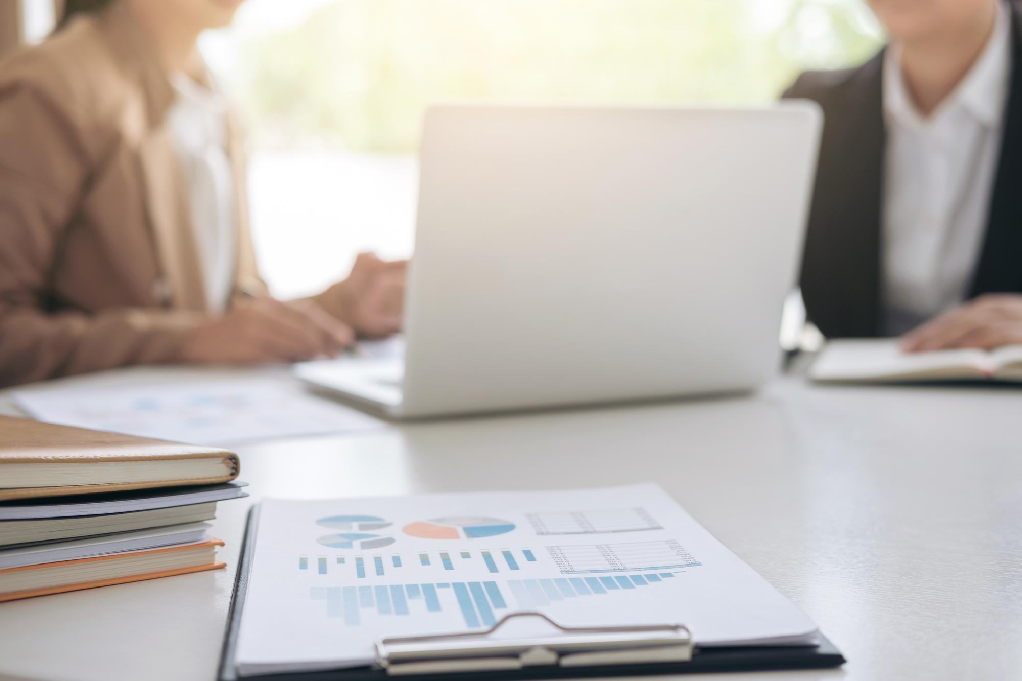Beratungssituation mit Laptop und Finanzunterlagen